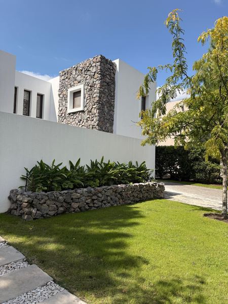Cantero elevado con muro de piedra y césped recién cortado